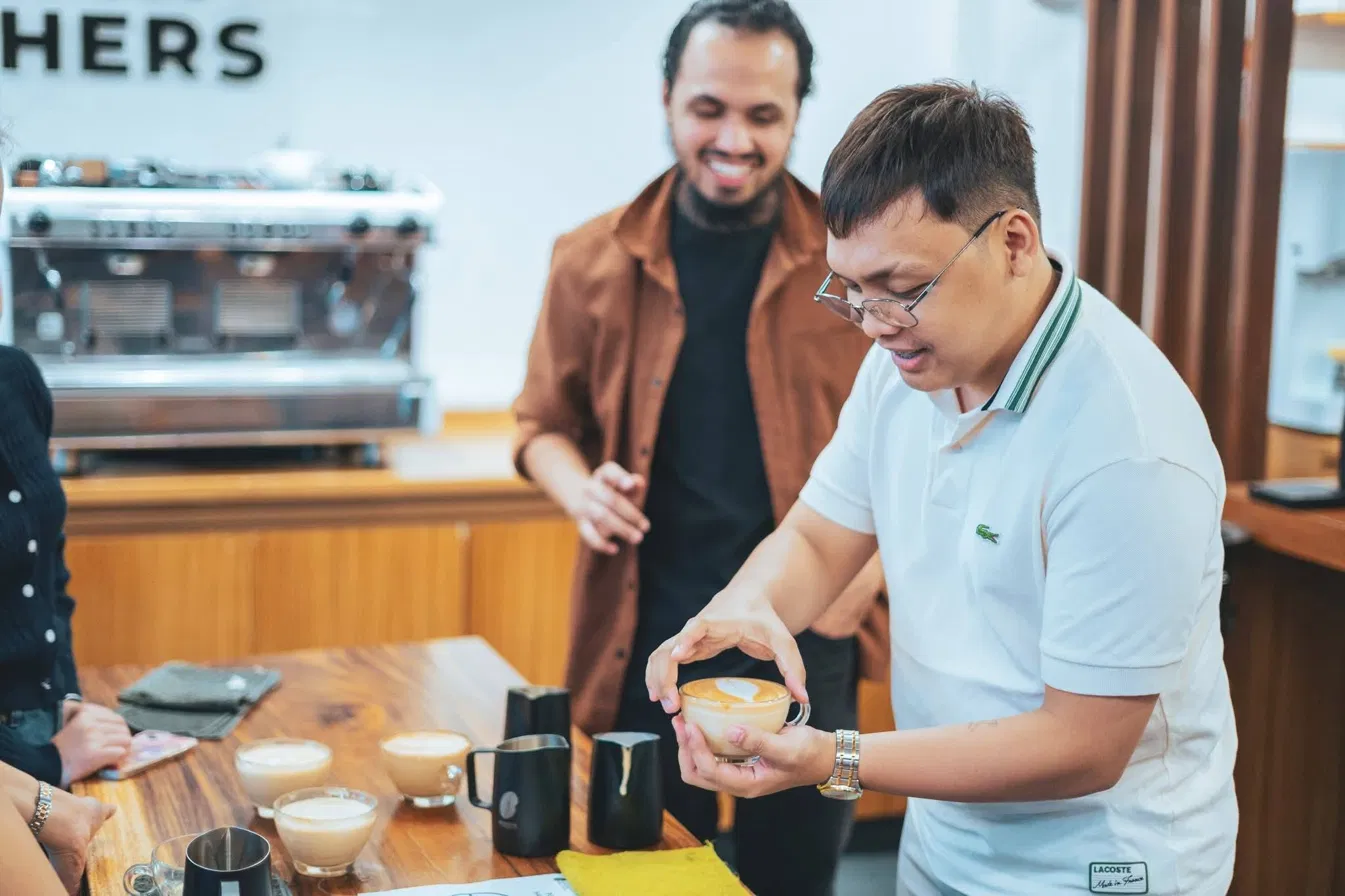 Barista presenting a latte with heart art